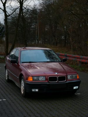 A classic red BMW parked in a scenic outdoor setting in Waldbröl, Germany.