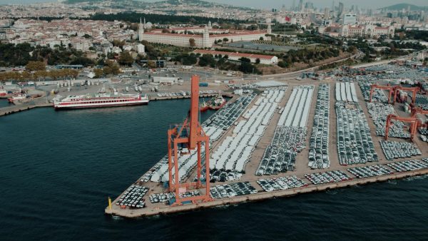 Aerial view of a bustling car shipping terminal in Istanbul, Türkiye, showcasing a busy port with vehicles ready for export.