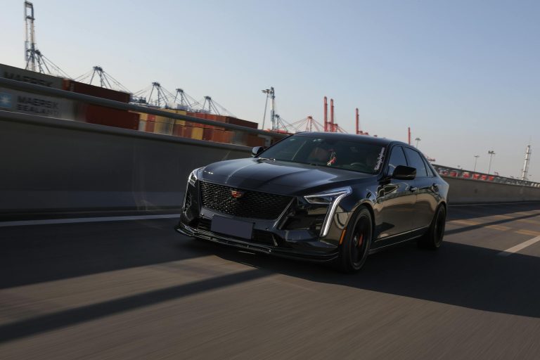 Capture of a black Cadillac CT6 in dynamic motion on an urban highway.